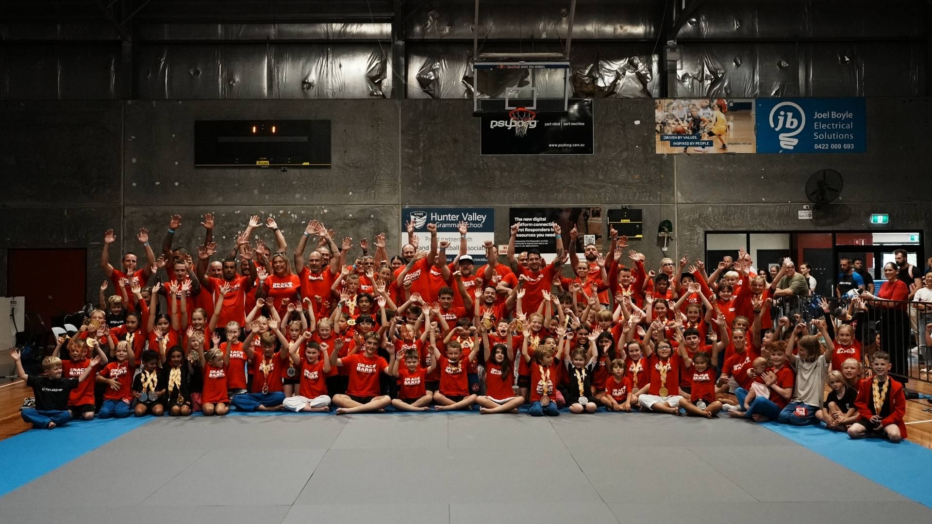 Gracie Barra athletes in red competition uniforms at the CompNet Hunter Valley Brazilian Jiu-Jitsu State Championship 2026 in Australia